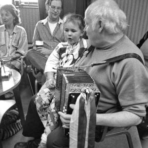 man playing accordion w girl on his knee