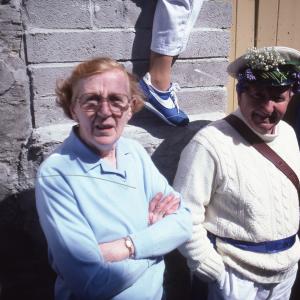 People stood against wall in sun