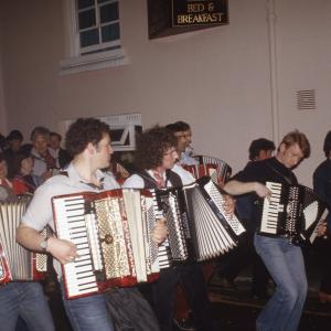 accordion players playing in procession at night