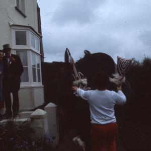 Old Oss dancing in someone's garden and Master of Ceremonies greeting women at their front door