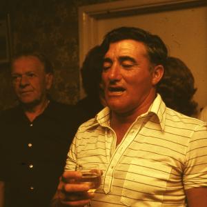 Man singing in pub, surrounded by people in fancy dress