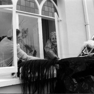 Old Oss being stroked by women from inside house