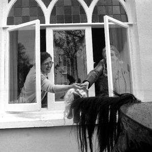 Old Oss being stroked by women from inside house