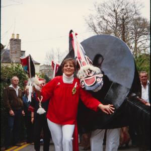 Woman holding club, posing with Old Oss