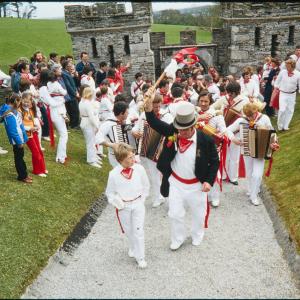 Master of Ceremonies leading Old Oss band procession out of Prideaux Place gate