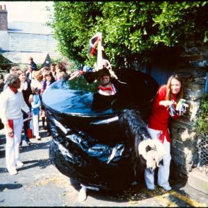 Old Oss rider peaking out from under hat, posing with woman