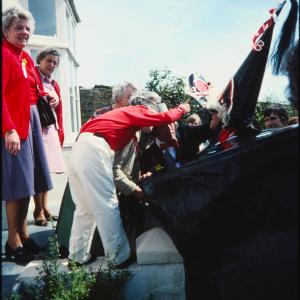 Old Oss greeting women at their house