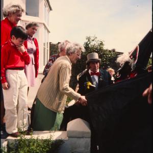 Old Oss greeting women at their house