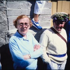 People stood against wall in sun