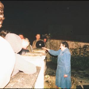 Woman at garden wall at night