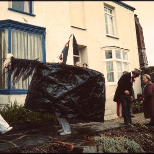 Old Oss dancing in someone's garden and Master of Ceremonies greeting women at their front door