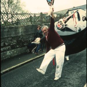 Man holding club up to sky in front of Old Oss