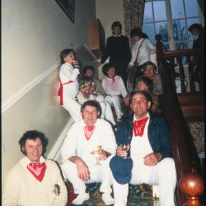 People holding drinks on steps of house