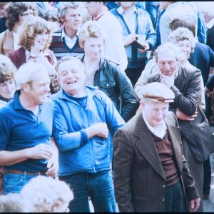 People stood in crowd smiling and laughing