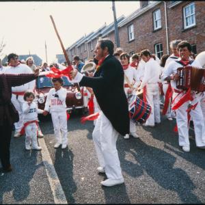Old Oss procession in road, Master of Ceremonies dancing at front