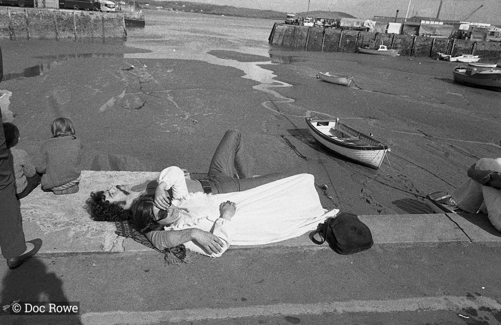 Visitors lying down by the harbour