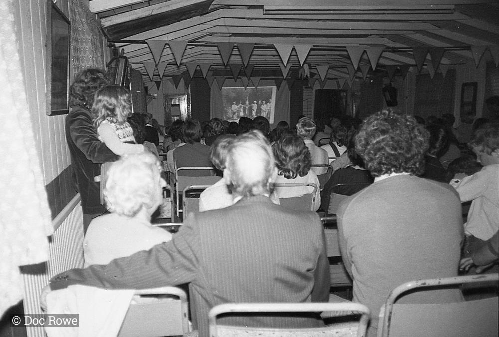 People watching slide show presenting Doc Rowe's photos