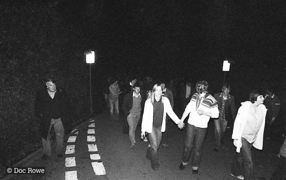 people walking in road at night