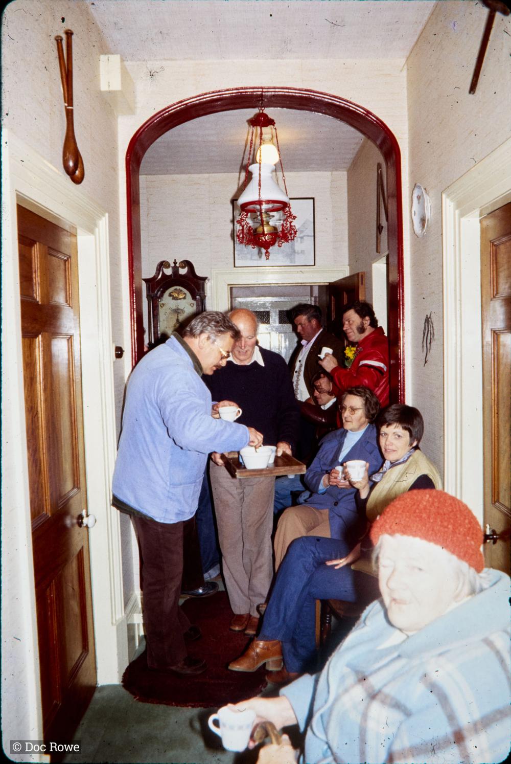 Night time, people drinking tea in a house hallway