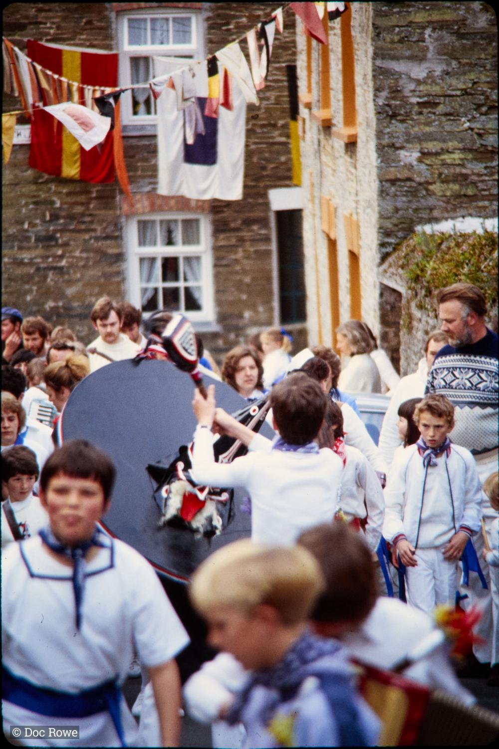 View down street, Blue Ribbon Oss being teased by boy, people walking