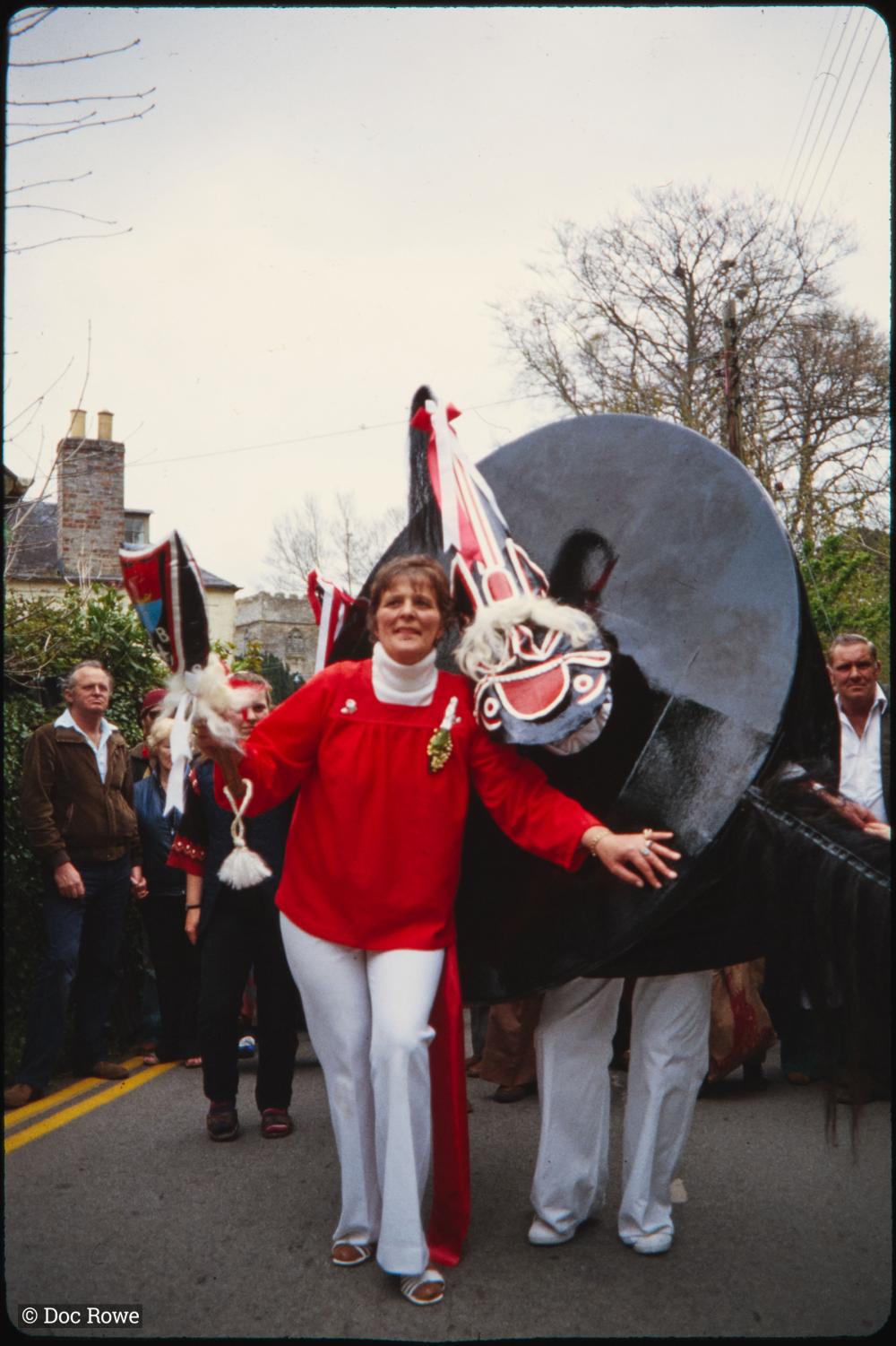 Woman holding club, posing with Old Oss