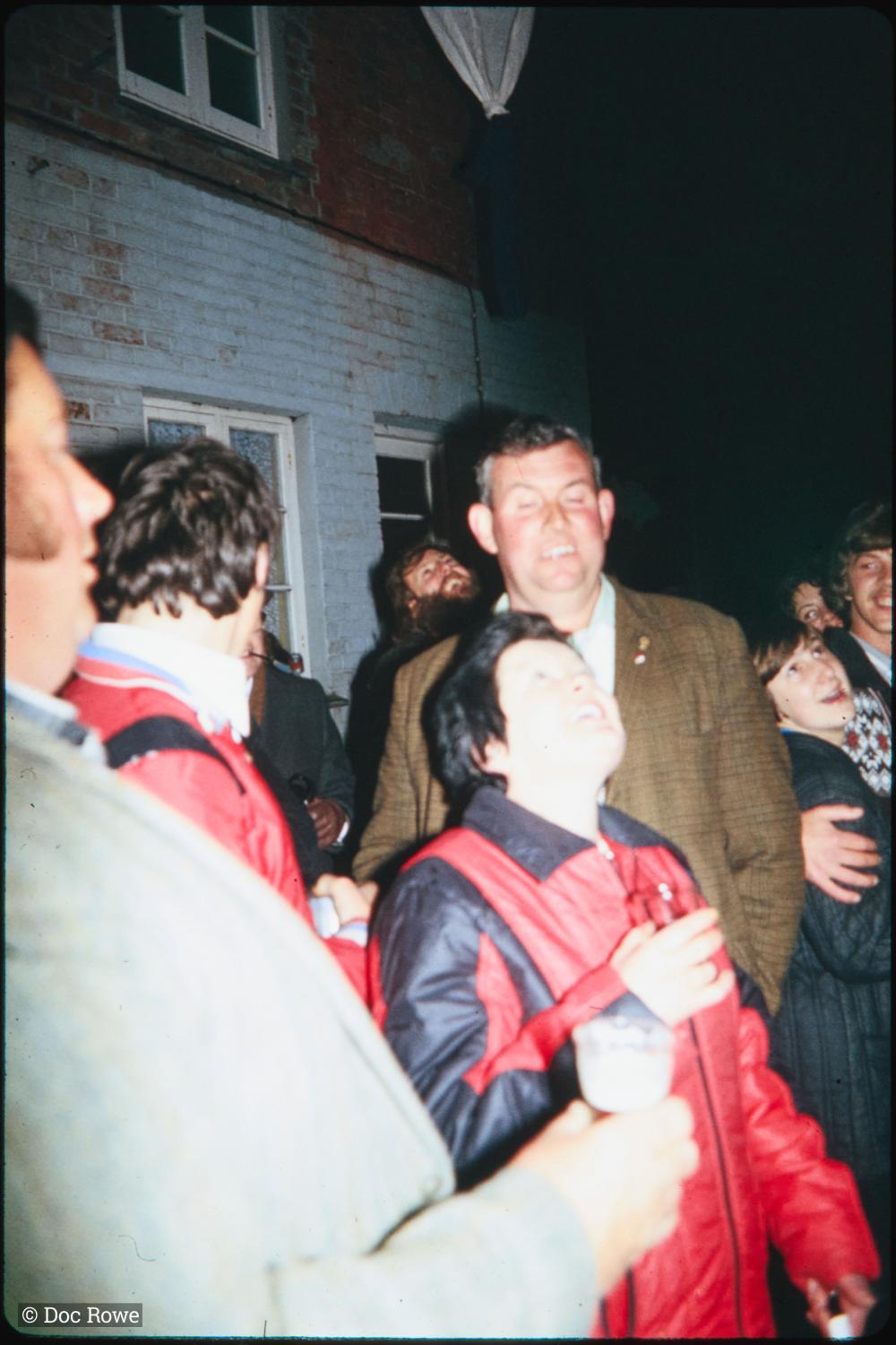 People outside The Harbour Inn at night