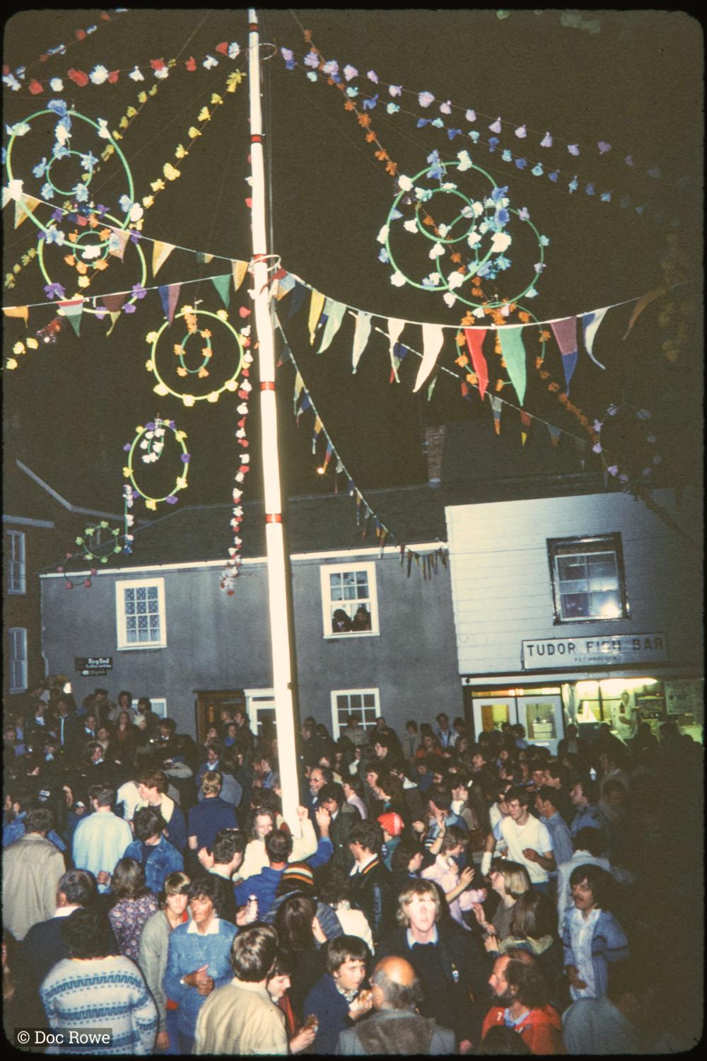 Maypole at night with crowd