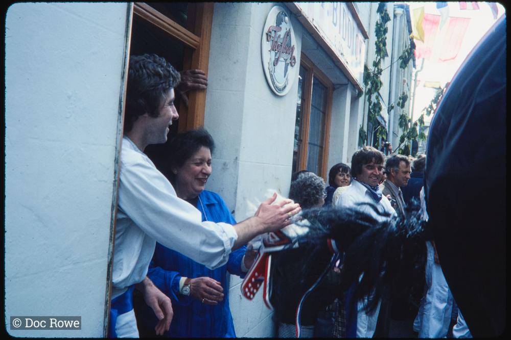 People in shop doorway stroking Blue Ribbon mane 