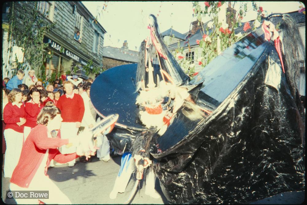 Woman teasing both the osses under the maypole