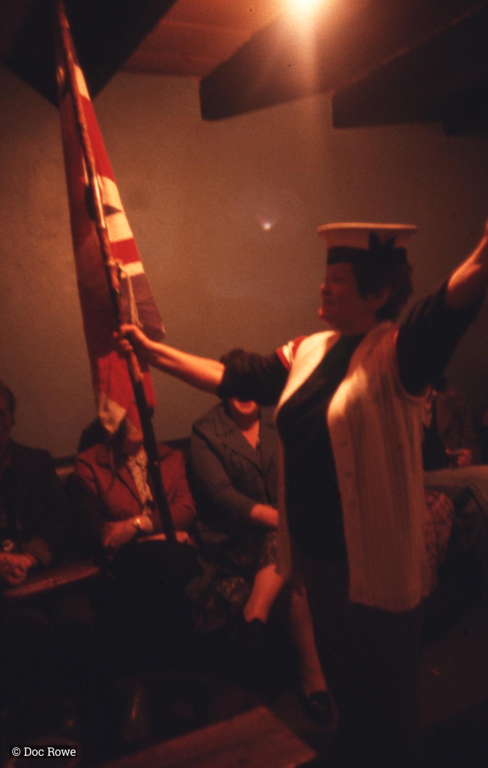 Woman singing, holding union flag 