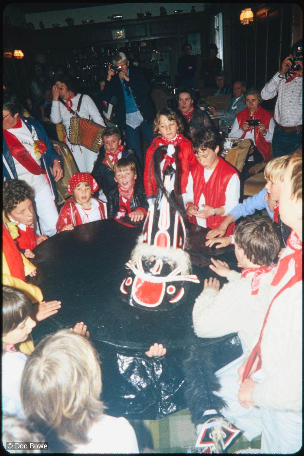 Children circled around Old Oss inside