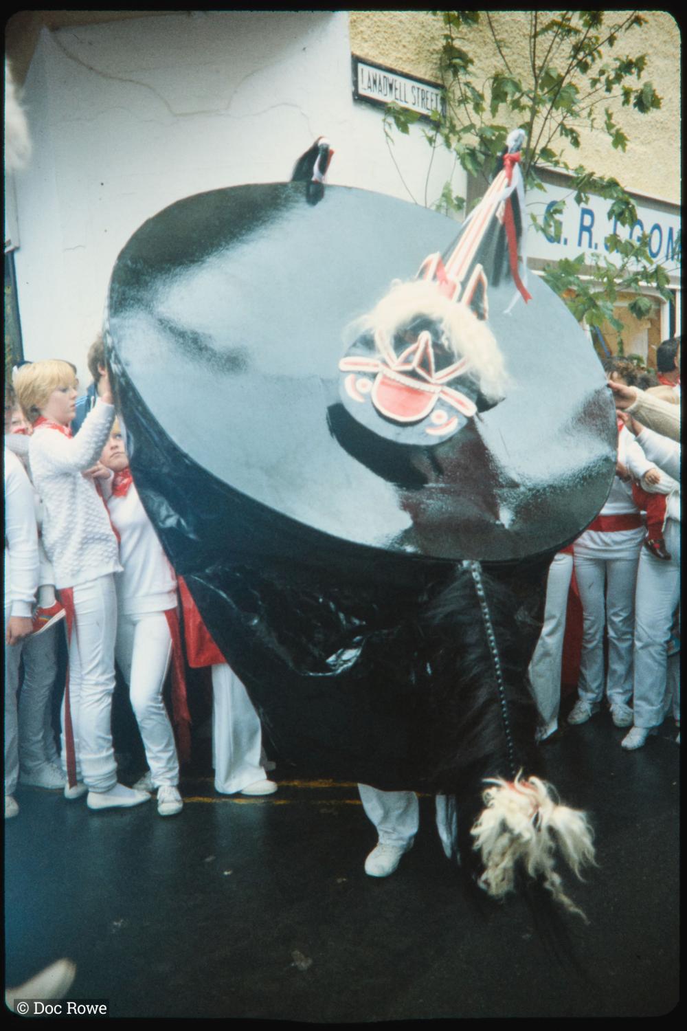 Old Oss on street corner, surrounded by dancers