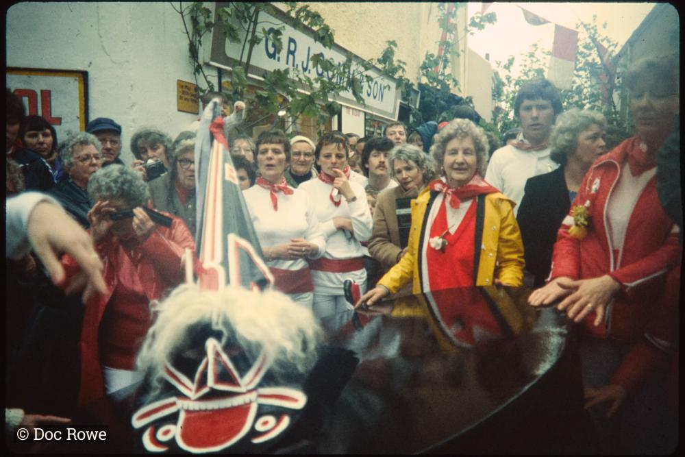 Old Oss on street corner with spectators and dancers