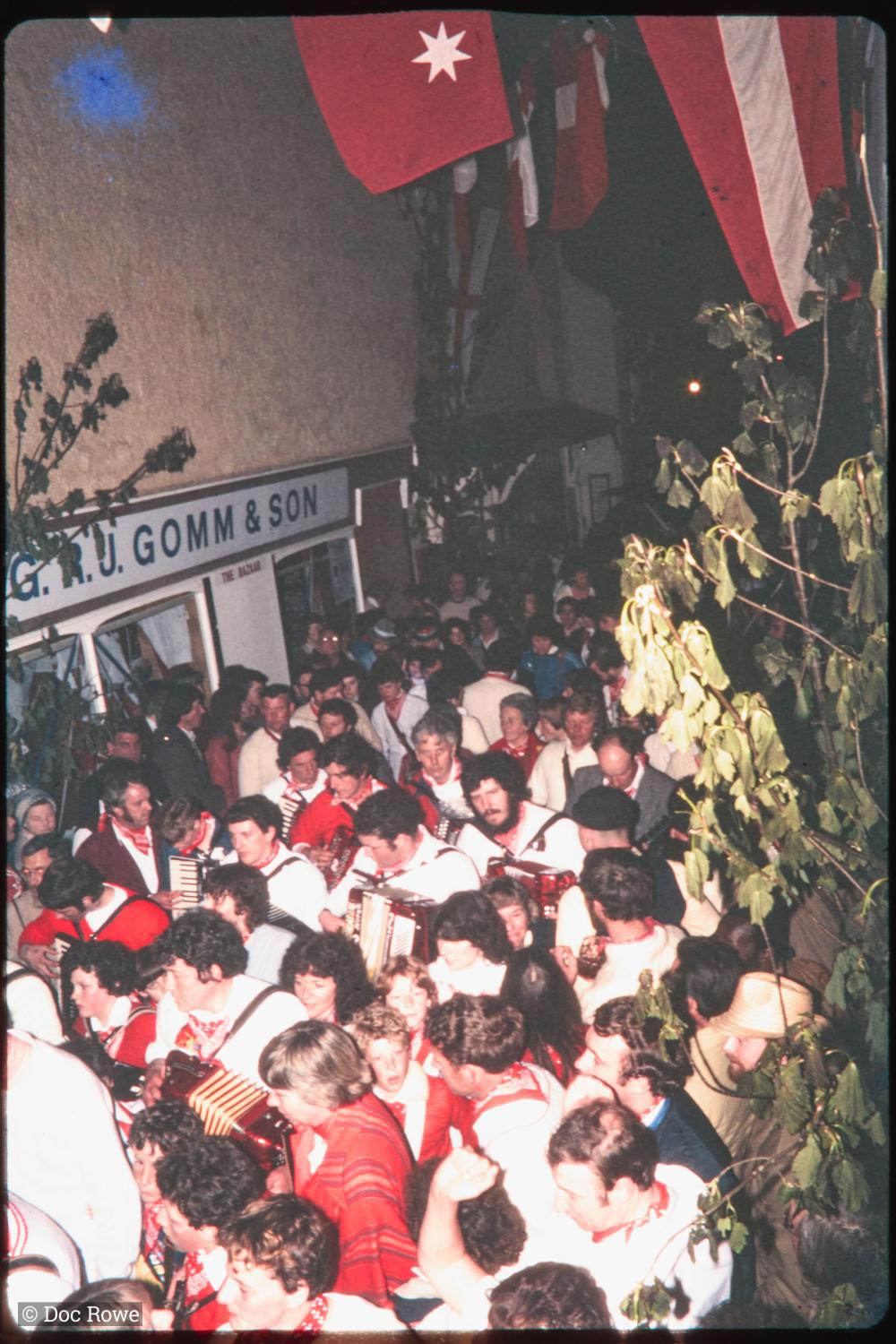 Procession in very crowded Lanadwell street at night