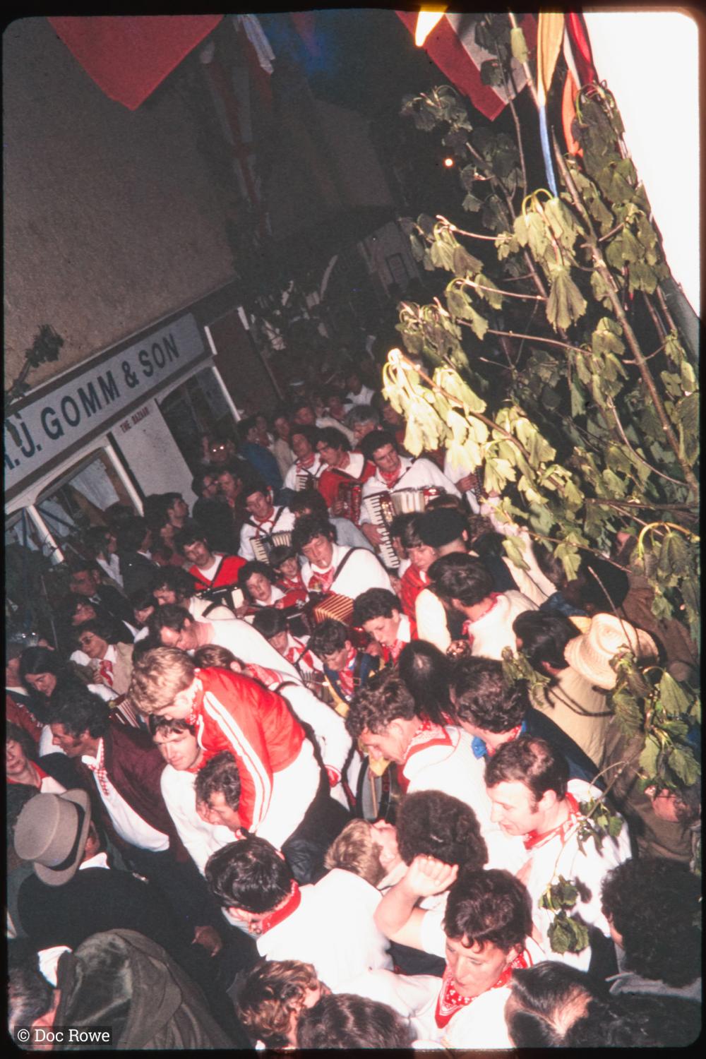 Procession in very crowded Lanadwell street at night