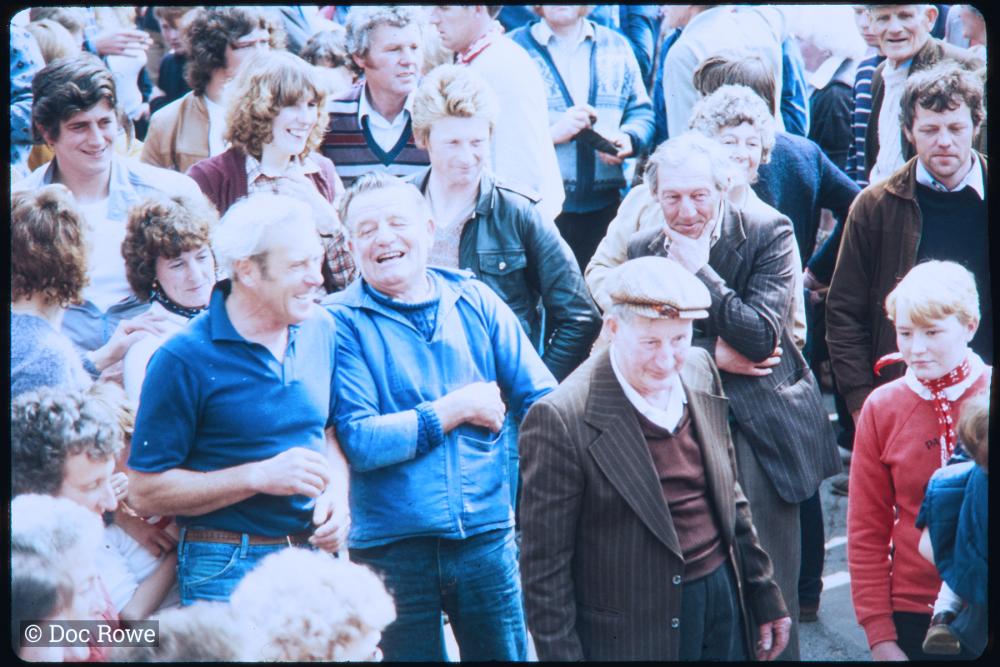 People stood in crowd smiling and laughing