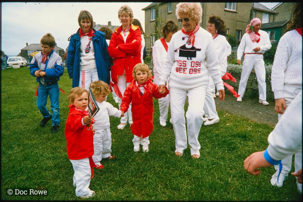Children holding hands with lady from Old Oss and holding teasing club