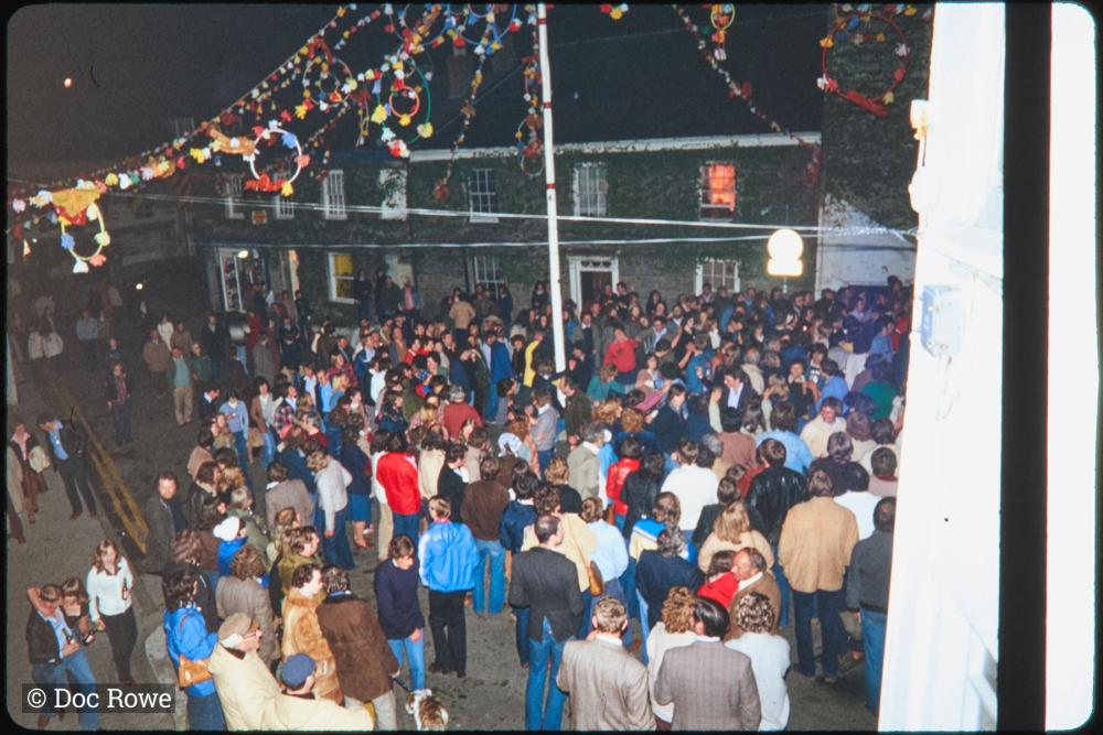 Crowd gathered around maypole at night