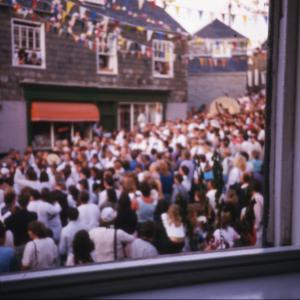 Crowds under maypole, from window