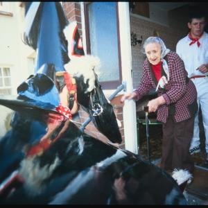Old Oss greeting woman at her front door