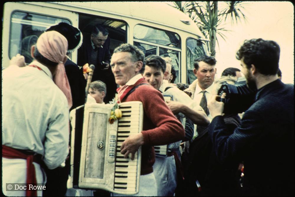 Accordion players getting off of a coach
