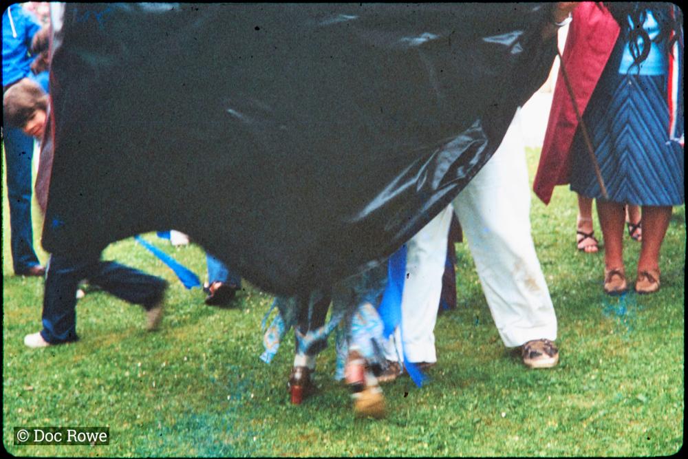 Man and woman's legs under Blue Ribbon Oss costume