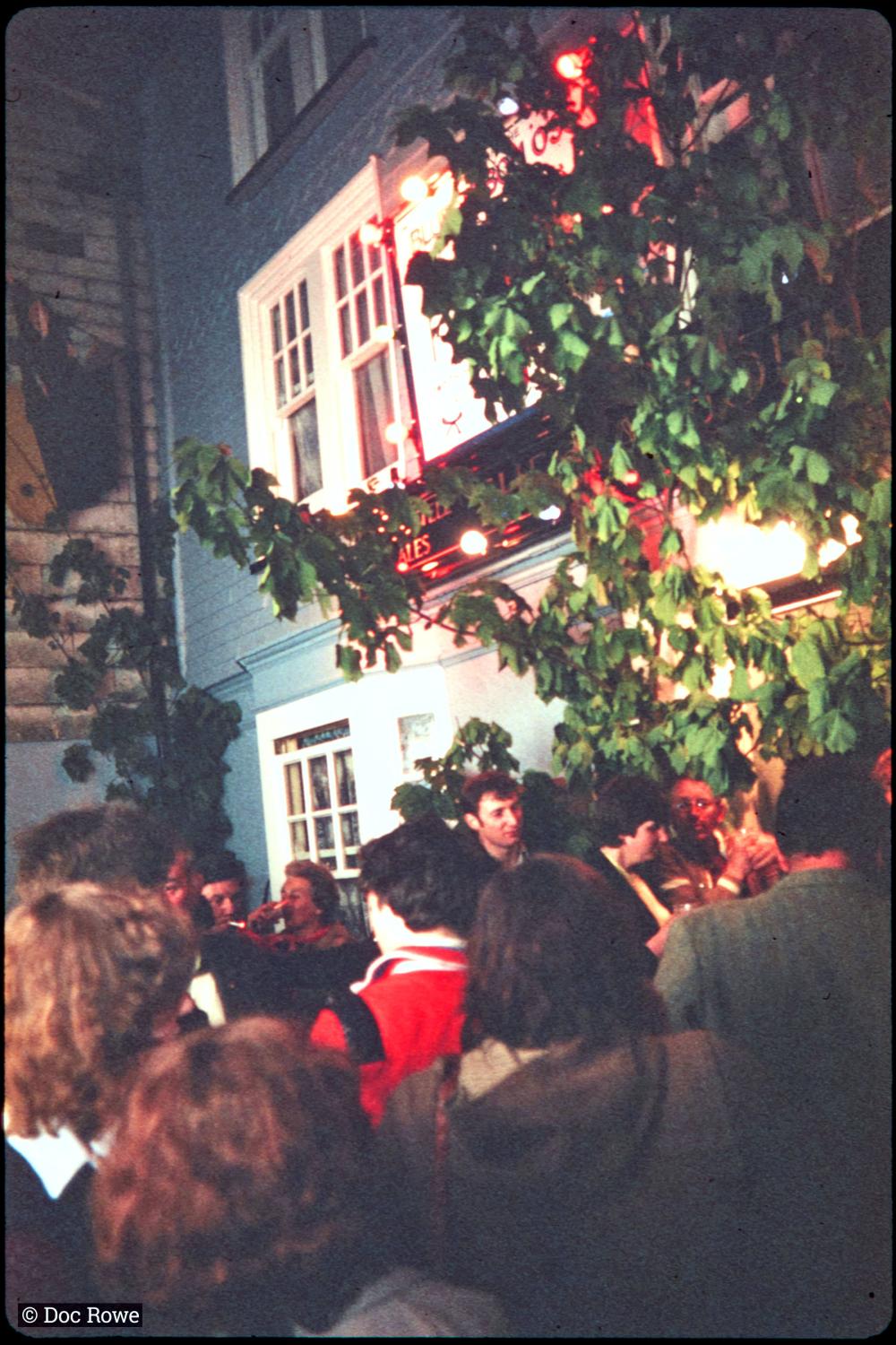 People outside The Harbour Inn at night