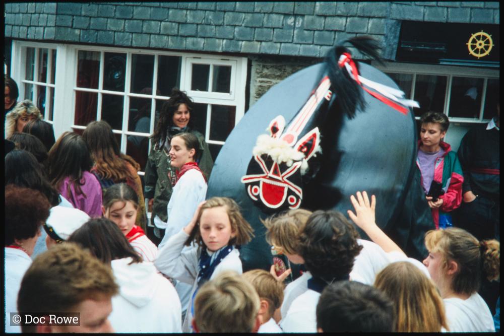 Old Oss in procession in narrow street